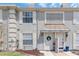 Charming townhome with well-maintained lawn, decorative door awning, and neutral color palette at 14053 Notreville Way, Tampa, FL 33624