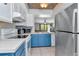 Charming kitchen with blue cabinets, tile backsplash, and modern stainless steel appliances at 14053 Notreville Way, Tampa, FL 33624