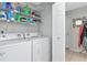 Practical laundry area with white washer/dryer units, shelving, and convenient storage solutions at 14053 Notreville Way, Tampa, FL 33624