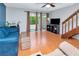 Inviting living room with hardwood floors, bright windows, and adjacent wooden staircase at 14053 Notreville Way, Tampa, FL 33624