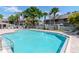 Relaxing community pool with surrounding deck, lounge chairs and palm trees at 14053 Notreville Way, Tampa, FL 33624