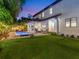 Inviting backyard featuring a sparkling pool, covered patio, fire pit, and lush landscaping, perfect for outdoor relaxation at 150 Chippewa Ave, Tampa, FL 33606