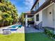 Backyard oasis with a sparkling pool, covered patio, lush green turf, and outdoor seating, perfect for entertaining at 150 Chippewa Ave, Tampa, FL 33606