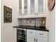 Elegant bar area featuring a wine refrigerator, sleek countertop, and stylish glass-front cabinets at 150 Chippewa Ave, Tampa, FL 33606