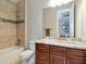 This bathroom features a tub with shower, a single sink vanity with a marble countertop and beautiful cabinets at 150 Chippewa Ave, Tampa, FL 33606