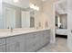 Elegant bathroom with a double sink vanity with granite counters, and a doorway view to the main bedroom at 150 Chippewa Ave, Tampa, FL 33606