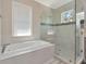 Bright bathroom featuring a soaking tub and a glass-enclosed shower with natural light from the window at 150 Chippewa Ave, Tampa, FL 33606