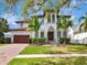 Elegant two-story home with well-manicured lawn, lush landscaping, and a tile roof, creating a welcoming curb appeal at 150 Chippewa Ave, Tampa, FL 33606