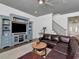 Inviting living room with a comfortable leather sectional, ceiling fan, and staircase at 150 Chippewa Ave, Tampa, FL 33606