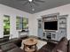 Cozy living room with a plush brown sofa, custom media center, and a large window with blinds at 150 Chippewa Ave, Tampa, FL 33606