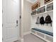 Bright mudroom featuring a built-in bench with blue cushion, storage cubbies, and convenient backpack hooks at 150 Chippewa Ave, Tampa, FL 33606