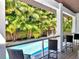 Outdoor entertainment area with a bar and seating overlooks the refreshing swimming pool and lush landscaping at 150 Chippewa Ave, Tampa, FL 33606