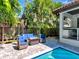 Outdoor patio features stylish seating, fire table, and bar area overlooking the beautiful pool surrounded by lush landscaping at 150 Chippewa Ave, Tampa, FL 33606