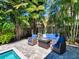 Outdoor patio featuring stylish seating and a fire table, all surrounded by lush landscaping for a relaxing outdoor experience at 150 Chippewa Ave, Tampa, FL 33606