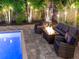 Stunning patio space with comfortable seating, fire pit, and lush greenery, perfect for relaxation and entertainment by the pool at 150 Chippewa Ave, Tampa, FL 33606