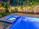 Backyard pool with a spa lit up at night surrounded by lush landscaping and creating a relaxing backyard retreat at 150 Chippewa Ave, Tampa, FL 33606