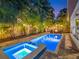 Backyard pool with a spa lit up at night surrounded by lush landscaping and creating a relaxing backyard retreat at 150 Chippewa Ave, Tampa, FL 33606