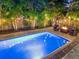 Backyard pool area with a fire pit for evening gatherings and relaxation, surrounded by garden lights at 150 Chippewa Ave, Tampa, FL 33606