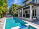 Inviting pool area with a covered patio, outdoor furniture, and a lush tropical backdrop for ultimate relaxation at 150 Chippewa Ave, Tampa, FL 33606
