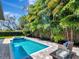 Refreshing pool and spa surrounded by a patio, outdoor furniture, and lush landscaping, perfect for leisure and relaxation at 150 Chippewa Ave, Tampa, FL 33606