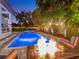 Beautiful backyard with a sparkling pool, spa, fire pit, and outdoor seating, perfect for evening entertainment and relaxation at 150 Chippewa Ave, Tampa, FL 33606