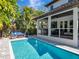 Sun-drenched pool and patio with comfortable seating, lush trees, and a covered patio for outdoor enjoyment at 150 Chippewa Ave, Tampa, FL 33606