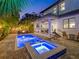 Beautiful pool and spa illuminated at dusk, surrounded by lush landscaping and an inviting outdoor living area at 150 Chippewa Ave, Tampa, FL 33606