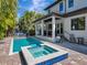 Beautiful backyard pool and spa with an outdoor kitchen, grill, seating, and lush tropical landscaping at 150 Chippewa Ave, Tampa, FL 33606