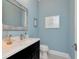 Stylish powder room featuring blue walls, decorative mirror, and modern fixtures at 150 Chippewa Ave, Tampa, FL 33606