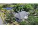 Aerial view of house showing a serene backyard with mature trees and a pond nearby at 15702 Richboro Ct, Tampa, FL 33647
