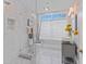 Modern bathroom with glass-enclosed shower, stylish vanity, and decorative tile accents, offering a sleek design at 15702 Richboro Ct, Tampa, FL 33647