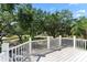 Inviting outdoor deck with white railings offers scenic views of the lush, tree-lined neighborhood at 15702 Richboro Ct, Tampa, FL 33647