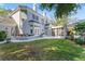 Exterior of home showing the backyard lawn, landscaping, and access to screened-in pool at 15702 Richboro Ct, Tampa, FL 33647