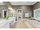 Open main bathroom with double vanity sinks, a soaking tub, and ample natural light at 15702 Richboro Ct, Tampa, FL 33647