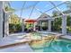 Screened-in pool with hot tub and cabana featuring outdoor dining at 15702 Richboro Ct, Tampa, FL 33647
