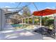 The screened-in pool has a hot tub, lounge seating, and an orange umbrella at 15702 Richboro Ct, Tampa, FL 33647