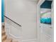 Staircase with a handrail leads to a hallway with colorful artwork at 15702 Richboro Ct, Tampa, FL 33647