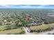 Community aerial view displaying houses around a serene pond and lush green landscape at 15861 Starling Water Dr, Lithia, FL 33547