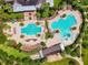 Aerial view of the neighborhood pools, splash pad and lounge area surrounded by trees at 15861 Starling Water Dr, Lithia, FL 33547