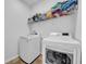 Functional laundry room with modern washer and dryer units and ample shelving at 15861 Starling Water Dr, Lithia, FL 33547