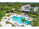 Aerial view of a community pool, featuring an accompanying lounge area with chairs, and lush tropical landscaping around the pool at 15861 Starling Water Dr, Lithia, FL 33547