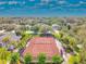Community tennis court with lights surrounded by beautiful mature trees and neighborhood houses at 15861 Starling Water Dr, Lithia, FL 33547