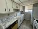 Cozy kitchen featuring white cabinets, faux marble countertops, and white appliances at 1830 Bough Ave # 4, Clearwater, FL 33760