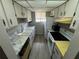 Galley kitchen featuring white cabinets, faux marble countertops, and natural light from a window at 1830 Bough Ave # 4, Clearwater, FL 33760
