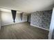 Spacious living room with faux stone accent wall, and luxury vinyl plank flooring at 1830 Bough Ave # 4, Clearwater, FL 33760