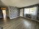 Living room featuring luxury vinyl plank flooring, natural light, and a faux stone accent wall at 1830 Bough Ave # 4, Clearwater, FL 33760