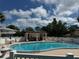 Community swimming pool surrounded by lush trees and a white picket fence at 1830 Bough Ave # 4, Clearwater, FL 33760