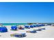 Beautiful white sandy beach with clear blue ocean and cabana-style beach furniture at 18400 Gulf Blvd # 1211, Indian Shores, FL 33785