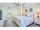 Bright bedroom features a four-poster bed, ceiling fan, and an ensuite bathroom view at 18400 Gulf Blvd # 1211, Indian Shores, FL 33785