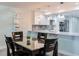 A dining area featuring a modern table with seating and a view of the kitchen, complete with stainless appliances at 18400 Gulf Blvd # 1211, Indian Shores, FL 33785